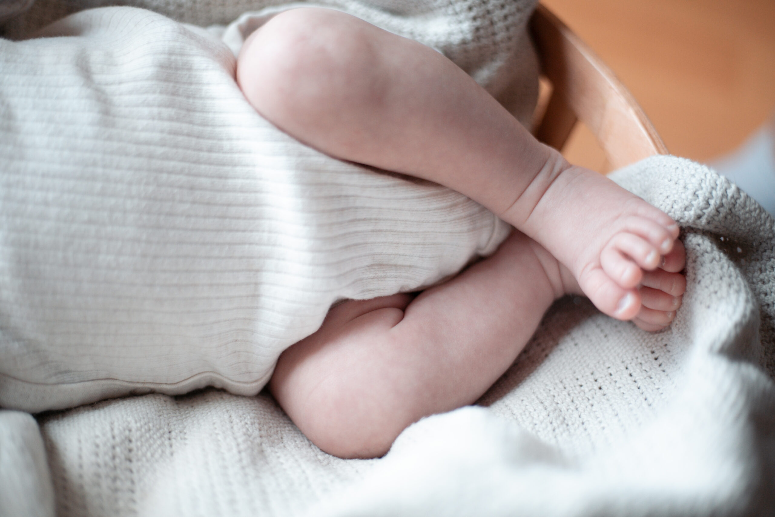 Babyfüßchen auf heller Strickdecke